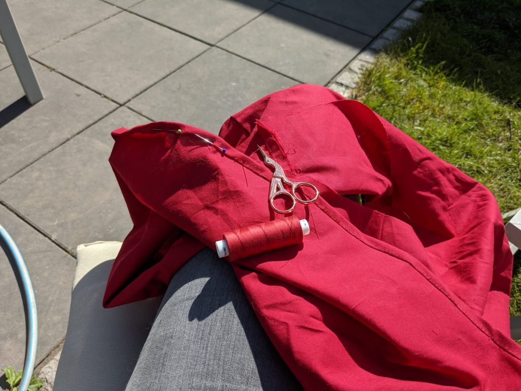 The skirt of the dress being whip stitched. 